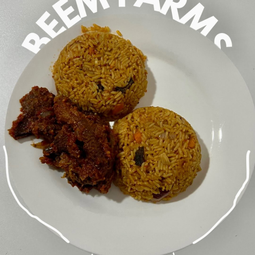 Close-up of jollof rice with generous chunks of beemfarms smoked ram meat